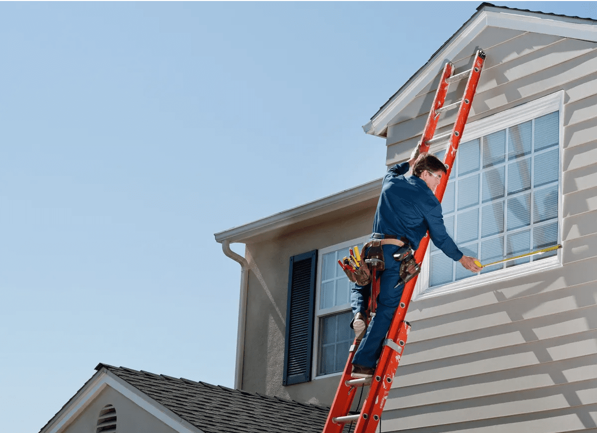 1745905168540_IMAGE-53512_20_281_29 Person on ladder cleaning house window.