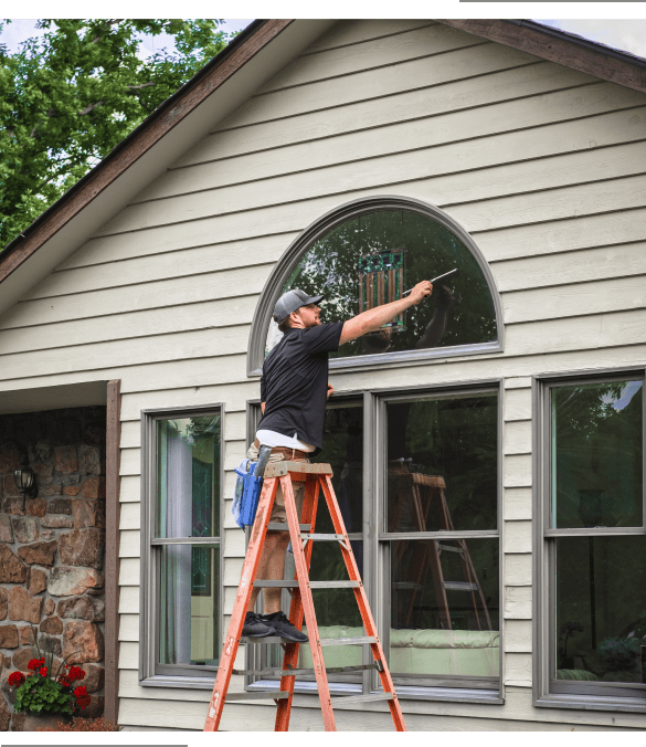 2 Man cleaning arched window on ladder.